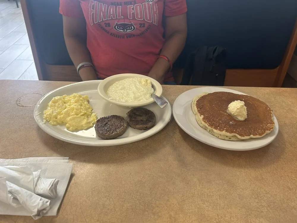 A breakfast plate with eggs, sausage, grits and a pancake at City Cafe in South Houston