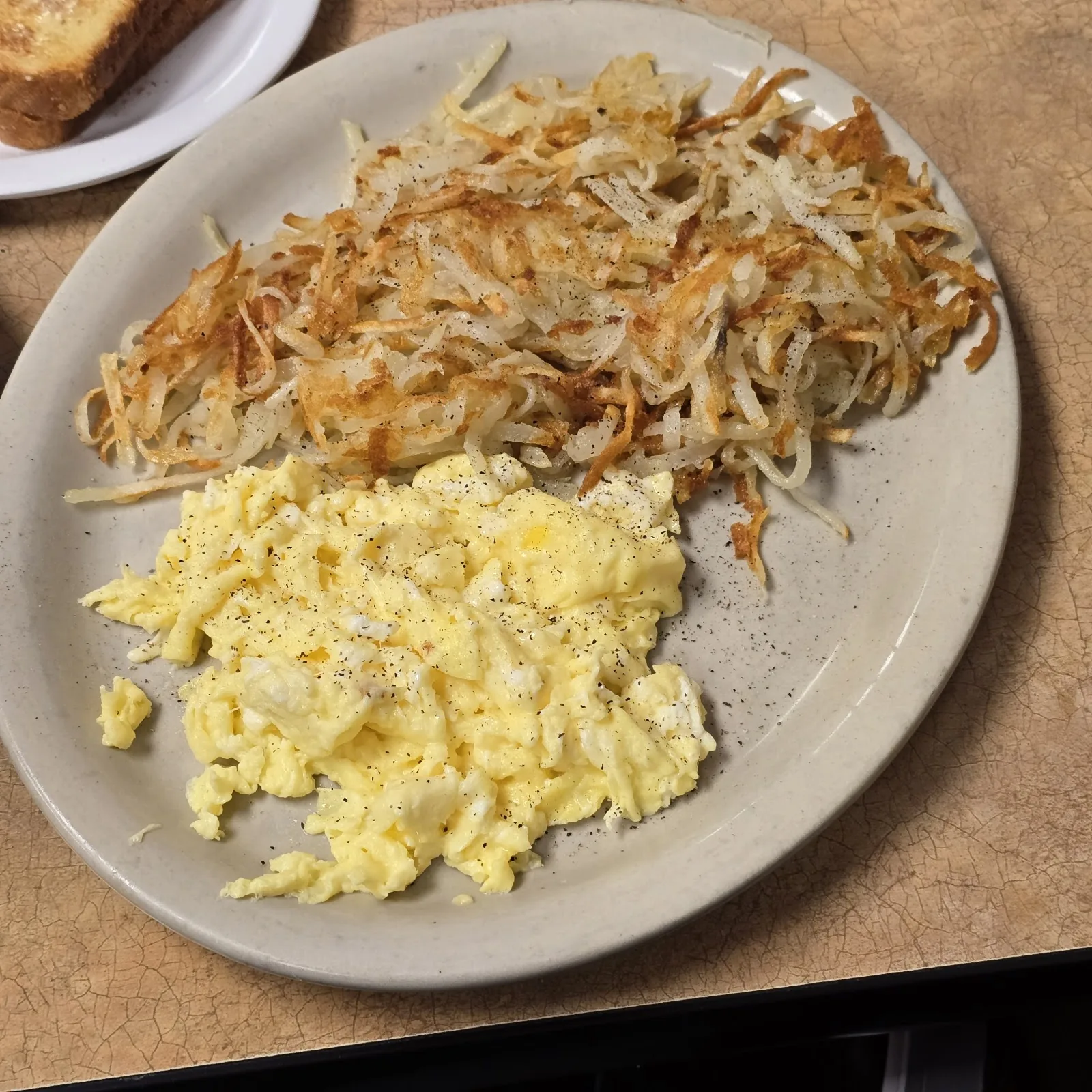 Scrambled eggs and crisp hash browns with toast on the side at City Cafe in South Houston